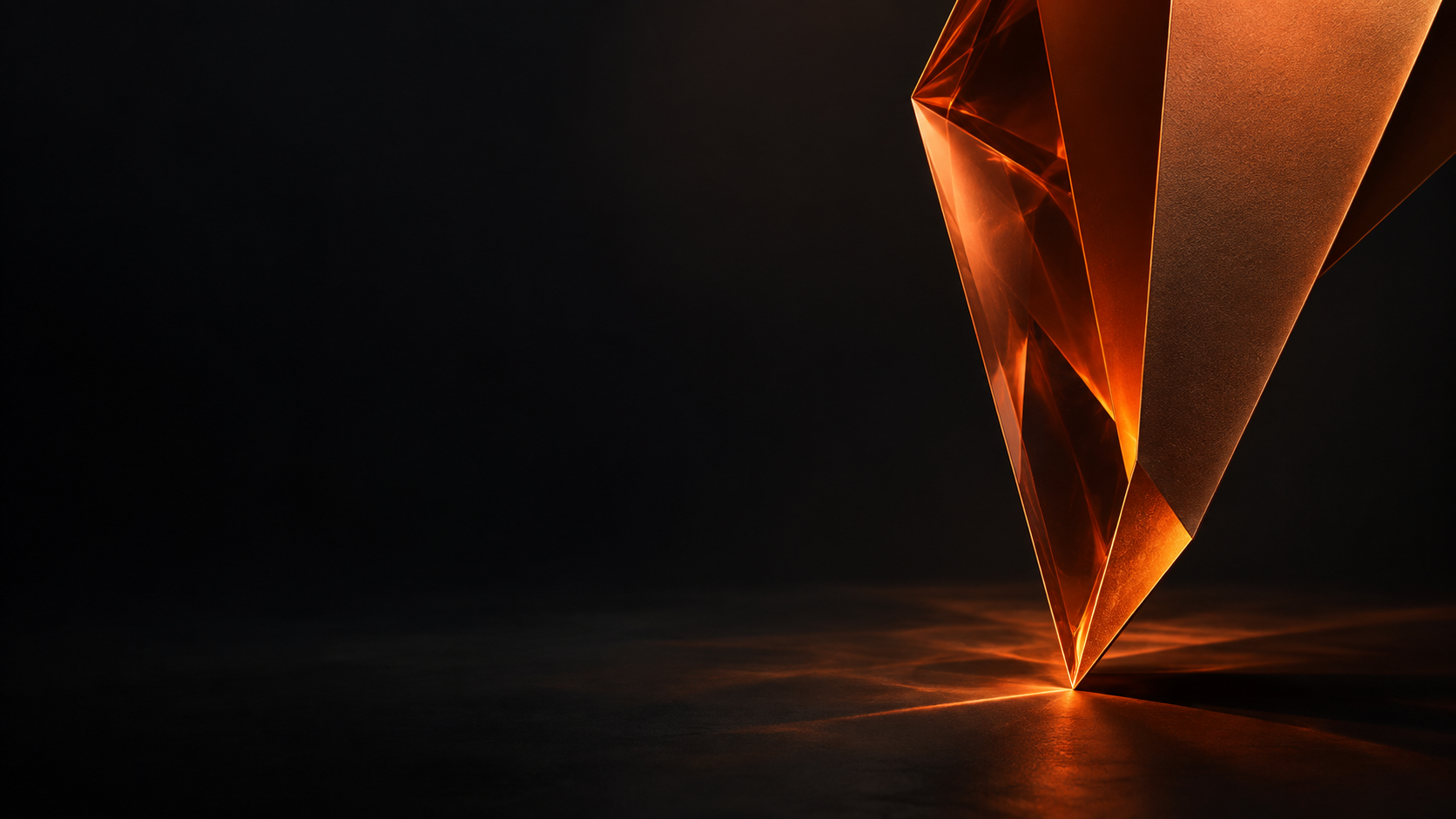 An angular orange glass form in a dark studio